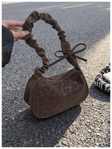 Détail d'un sac porté épaule léopard vintage avec bandoulière froncée et petit nœud