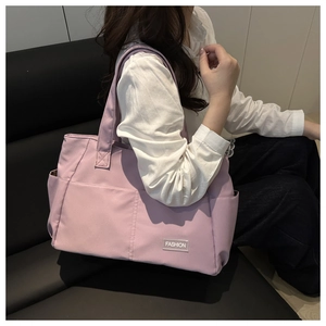 Close-up of lilac nylon tote bag with side pockets and a stylish fashion square label