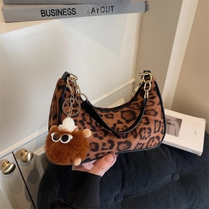 Trendy leopard print hobo bag with black leather trim and cute furry monster keychain charm
