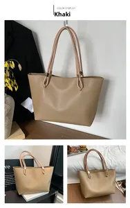 Detail view of khaki leather tote bag hanging on a suit and displayed on a table