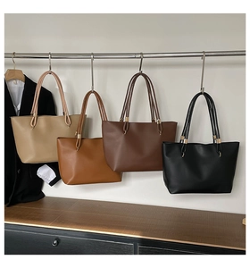 Detail view of large tote bags in beige, brown, coffee, and black on a display rack