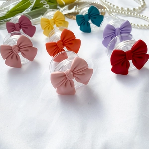 Detailed grid of colorful matte bow phone grips with transparent bases on white texture