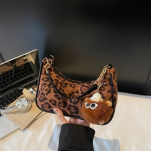 Trendy leopard print shoulder bag with gold chain strap and plush monster charm