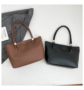 Close-up of brown and black leather tote bags with elegant gold metal buckles and matte finish