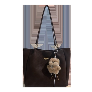 Retro chocolate leather tote bag with a plush bear charm and golden metal hardware detail
