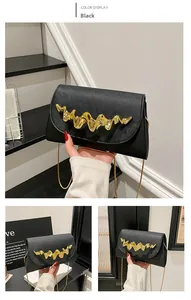 Détail de la texture cuir Saffiano noir avec élégante garniture métallique dorée ondulée
