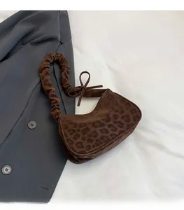 Dettaglio borsa a spalla leopardata con tracolla arricciata e fiocchi laterali decorativi