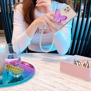 Détail d'un support de téléphone papillon en cristal violet avec cordon à perles