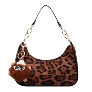 Leopard print crescent hobo bag with gold chain and plush monster charm accessory