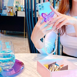 Détail d'un support de téléphone papillon en cristal violet et d'un cordon en perles