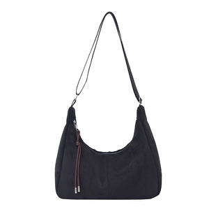 Minimalist black suede shoulder bag with retro fringe zipper detail and adjustable strap