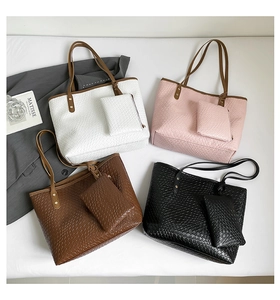 Detail view of woven leather tote bags in four colors with matching wristlet pouches