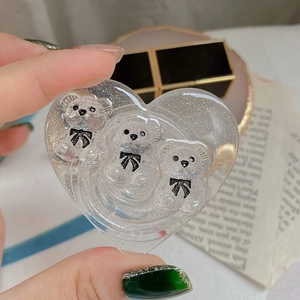 Macro shot of heart-shaped glitter resin accessory with 3D bears for phone grip