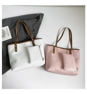 Detail of woven texture on large tote bag with brown leather handles and small pouch