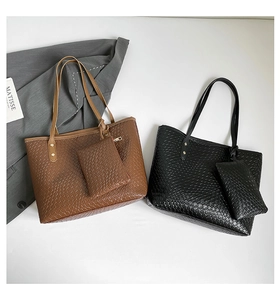 Detail of large woven texture tote bags in brown and black with matching small pouches