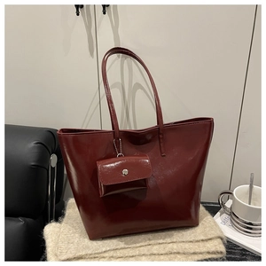 Detail of burgundy soft leather tote bag set with metal chain and mini pouch