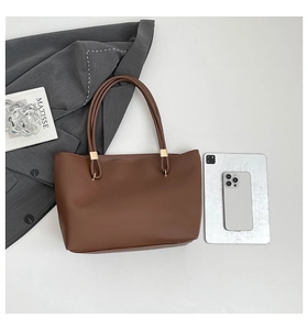 Top view of dark brown tote bag showing large capacity with tablet and phone comparison