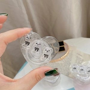 Detail of heart-shaped transparent glitter phone grip with three cute bear ornaments