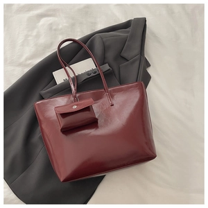 Macro shot of burgundy faux leather texture and mini coin purse on a large tote bag