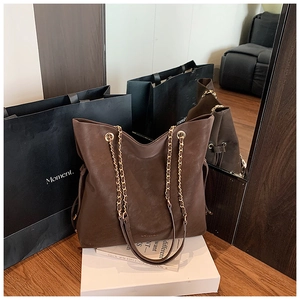 Retro coffee brown bucket bag with dual chain straps and sleek PU texture on display