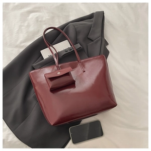 Macro view of burgundy vintage leather tote bag texture with matching mini flap coin purse