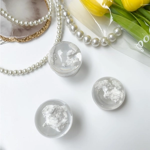 Detailed view of clear resin sphere phone grips featuring realistic white clouds design