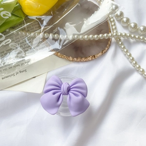 Detail shot of a matte purple bow phone socket grip on elegant vintage prop background