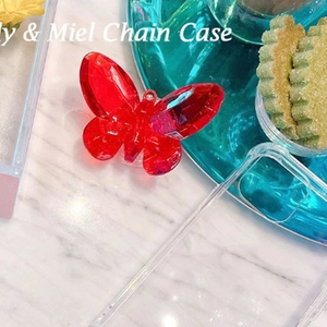 Gros plan du support papillon en cristal rouge de luxe sur coque transparente