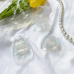 Close-up of clear resin phone grips with glitter, cute bear and candy shapes