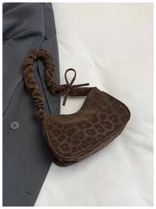 Détail du sac léopard en suédine avec nœud décoratif et bandoulière froncée