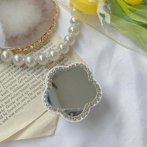 Support de téléphone en forme de fleur avec miroir et strass sur fond esthétique