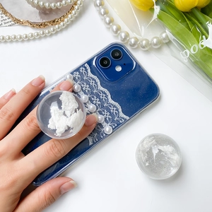 Detail view of navy blue phone case with white lace, pearls, and a clear 3D cloud grip