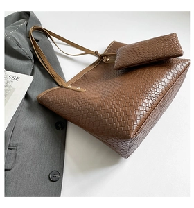 Close-up of brown woven leather tote bag with matching pouch and stylish magazine