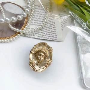 Macro detail of vintage gold embossed woman portrait phone socket with floral edges