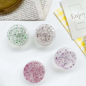 Detail view of colorful glitter resin phone grip sockets with silver and green sparkles