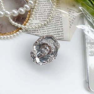 Close-up of vintage silver embossed portrait phone grip with Baroque scroll patterns