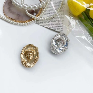 Detailed close-up of retro metal lady portrait phone stands in gold and silver finish