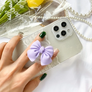 Purple ribbon bow phone grip stand on a glitter lace phone case with flowers