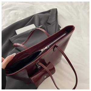 Detailed top view of the dark red leather tote bag with silver zipper and inner lining