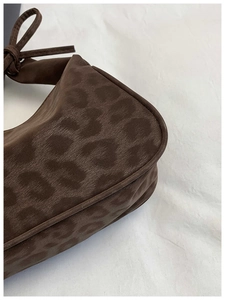 Détail du sac à bandoulière léopard marron café avec une poignée nouée distinctive
