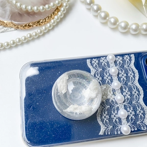 Detailed shot of a blue glitter phone case with a cloud-filled bubble socket and pearls