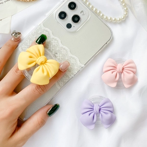 Cute bow-shaped collapsible phone grip sockets in pastel yellow, pink, and purple colors