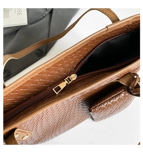 Close-up of brown woven tote bag featuring a secure zipper closure and fine texture