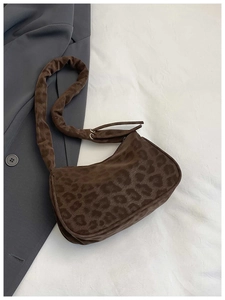 Détail d'un sac porté épaule imprimé léopard avec bandoulière plissée et anneaux métal