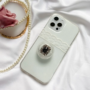 Detail view of a luxury white glitter phone case with lace decor and pearl grip holder