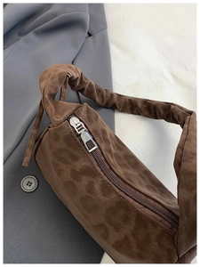 Détail du sac baguette léopard marron avec bandoulière froncée et fermeture éclair argentée