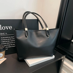 Minimalist black matte faux leather tote bag with gold hardware for urban women