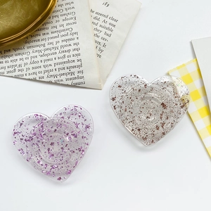 Close-up of heart-shaped phone grips with purple and gold glitter foil filling