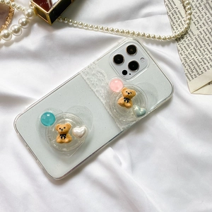 Detail view of a clear iPhone case with lace trim and two cute bear pop-up stands