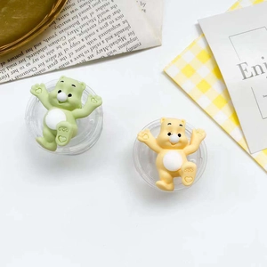Close-up of cute cartoon bear phone socket stands in pastel green and yellow resin